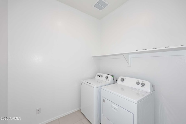 clothes washing area with independent washer and dryer, laundry area, baseboards, light tile patterned floors, and visible vents