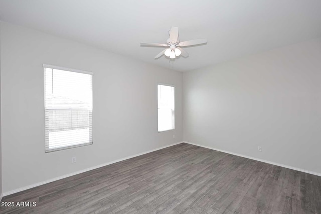 spare room featuring baseboards, ceiling fan, and wood finished floors