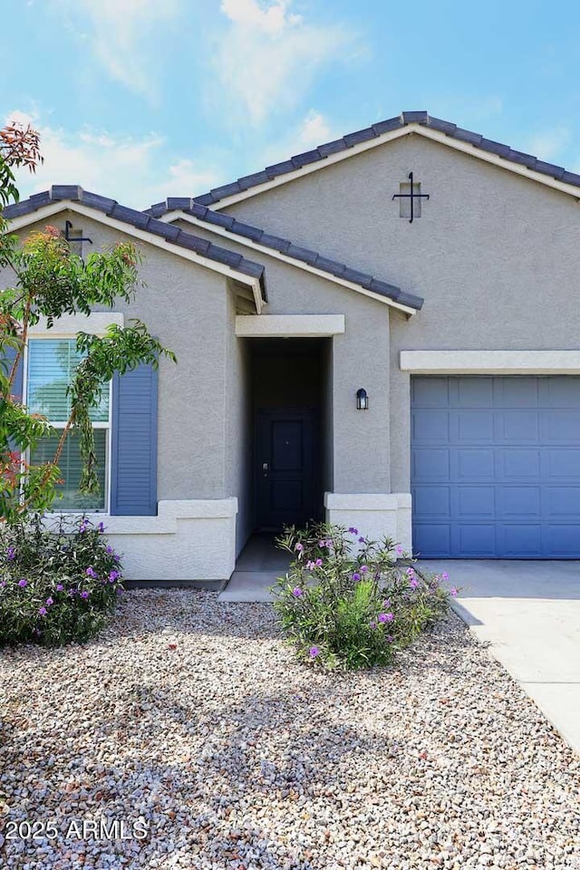 ranch-style home featuring a garage, driveway, and stucco siding