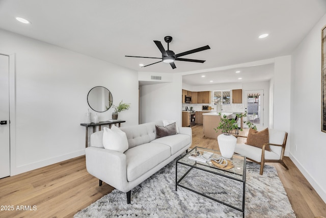 living room with baseboards, recessed lighting, visible vents, and light wood-style floors