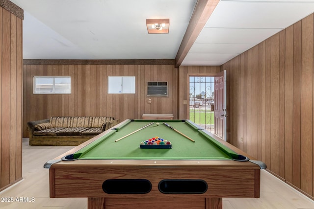 playroom with wood walls, beamed ceiling, a wall mounted air conditioner, and light wood-style floors