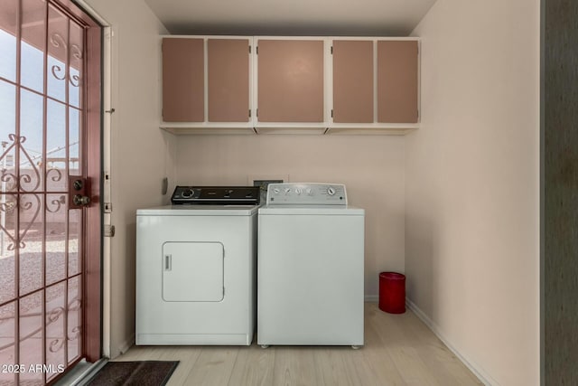 washroom with light wood finished floors, separate washer and dryer, cabinet space, and baseboards