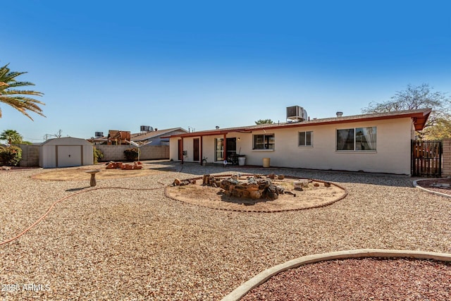 back of property with a storage shed, a fenced backyard, a patio, and an outbuilding