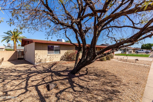 exterior space with brick siding and fence