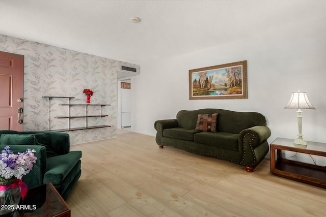 living room with wood finished floors and wallpapered walls