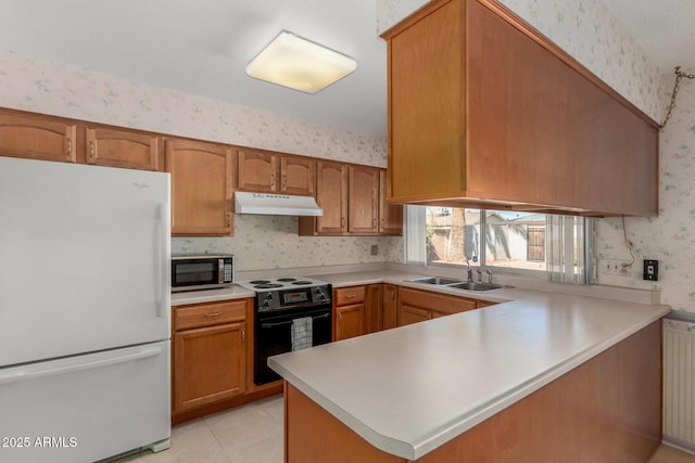 kitchen with stainless steel microwave, freestanding refrigerator, black range with electric cooktop, under cabinet range hood, and wallpapered walls