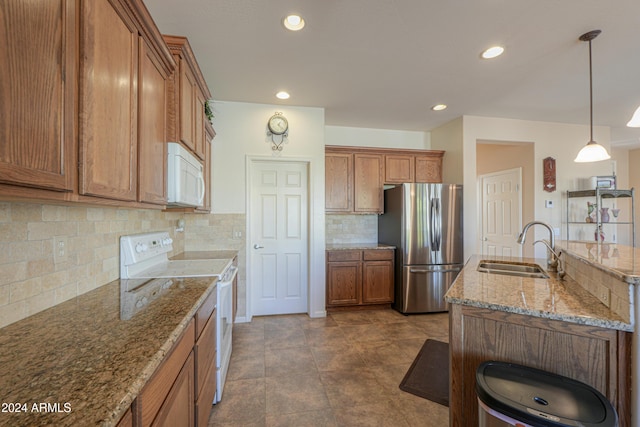 kitchen with pendant lighting, white appliances, sink, decorative backsplash, and light stone counters