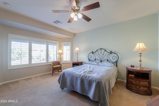 carpeted bedroom featuring multiple windows and ceiling fan