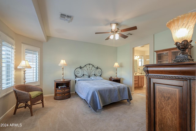 bedroom featuring ensuite bath, ceiling fan, and light carpet