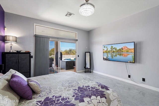 bedroom with concrete flooring, access to outside, and a chandelier