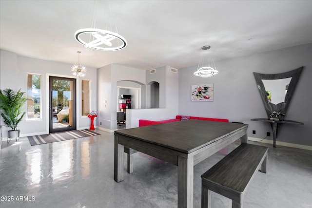 rec room with an inviting chandelier and concrete flooring