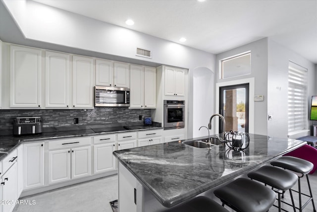 kitchen with an island with sink, appliances with stainless steel finishes, and sink