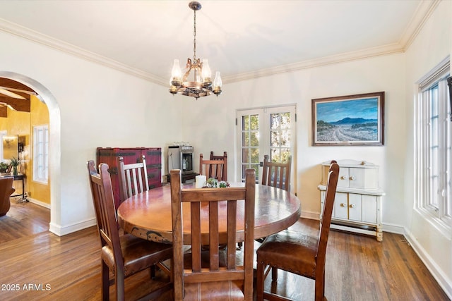 1614 Palmcroft Dr SW, Phoenix, AZ 85007 - dining room featuring arched walkways, wood finished floors, and ornamental molding