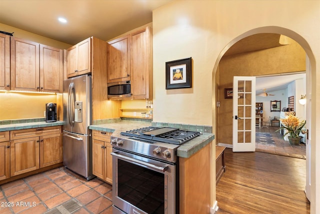 1614 Palmcroft Dr SW, Phoenix, AZ 85007 - kitchen with tile countertops, stainless steel appliances, arched walkways, and light wood finished floors