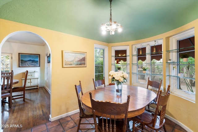 1614 Palmcroft Dr SW, Phoenix, AZ 85007 - dining space with arched walkways, baseboards, an inviting chandelier, and ornamental molding