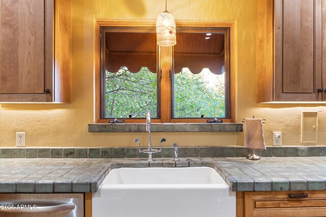 1614 Palmcroft Dr SW, Phoenix, AZ 85007 - kitchen with tile countertops, a sink, stainless steel dishwasher, a textured wall, and brown cabinets