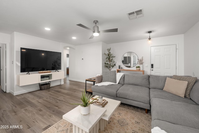 living area featuring recessed lighting, wood finished floors, arched walkways, ceiling fan, and visible vents