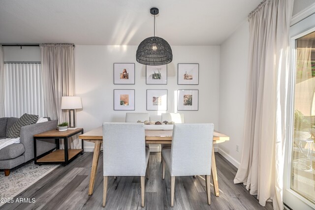 dining space with wood finished floors and baseboards