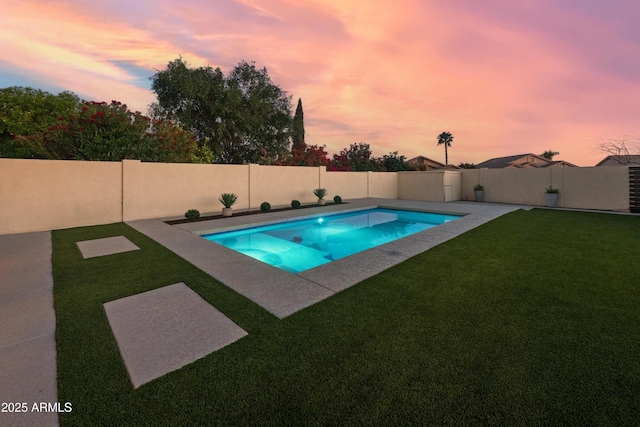 pool at dusk featuring a lawn, a fenced backyard, and a fenced in pool
