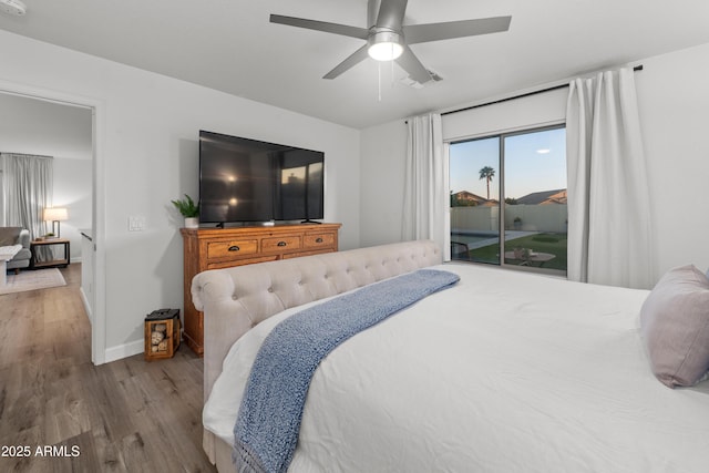 bedroom featuring ceiling fan, visible vents, baseboards, wood finished floors, and access to outside