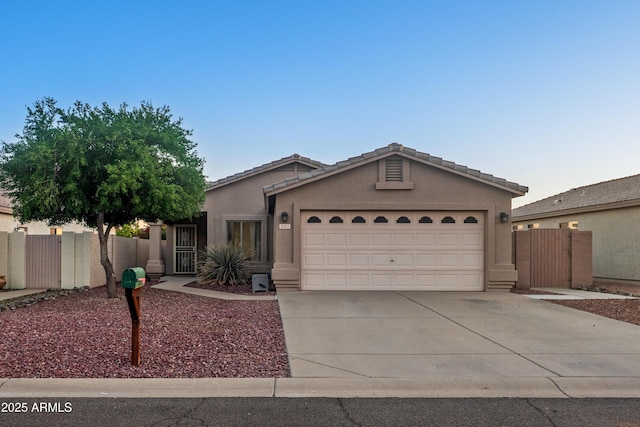 ranch-style home featuring concrete driveway, a garage, stucco siding, and fence