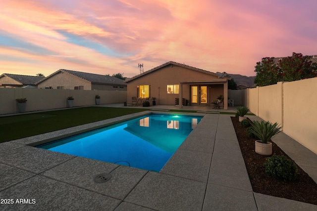 pool at dusk featuring a fenced in pool, a patio area, french doors, and a fenced backyard