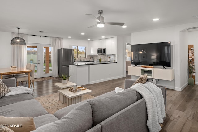 living area featuring recessed lighting, arched walkways, wood finished floors, ceiling fan, and french doors