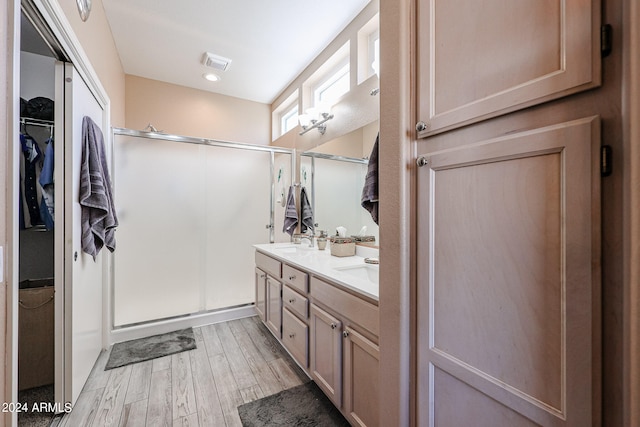 bathroom with vanity, an enclosed shower, and hardwood / wood-style flooring