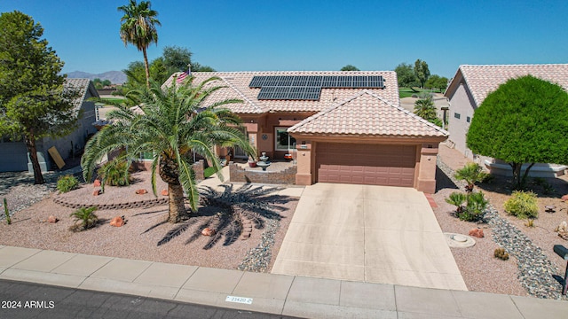 view of front of home featuring a garage and solar panels