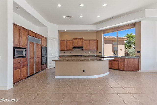 22463 N 54th St, Phoenix, AZ 85054 - kitchen featuring brown cabinets, under cabinet range hood, built in appliances, recessed lighting, and light tile patterned floors