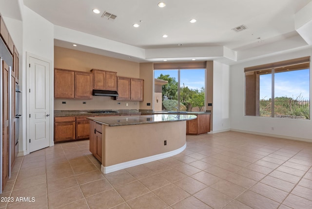 22463 N 54th St, Phoenix, AZ 85054 - kitchen featuring light tile patterned flooring, brown cabinetry, under cabinet range hood, a kitchen island, and recessed lighting