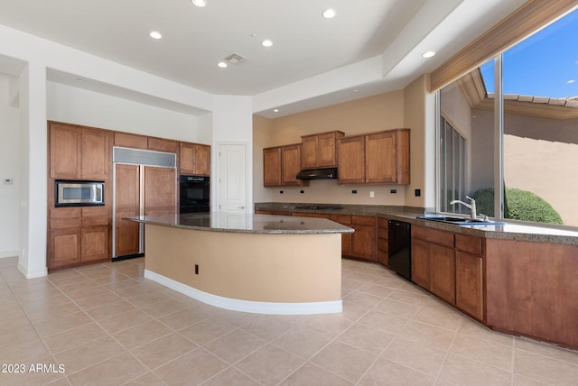 22463 N 54th St, Phoenix, AZ 85054 - kitchen featuring black appliances, brown cabinetry, a kitchen island, light tile patterned floors, and a sink