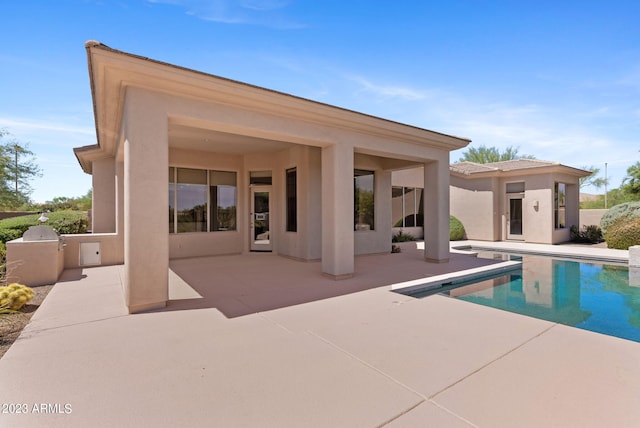 22463 N 54th St, Phoenix, AZ 85054 - rear view of property featuring a patio, an outdoor pool, stucco siding, and exterior kitchen