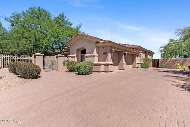 22463 N 54th St, Phoenix, AZ 85054 - view of front facade featuring a gate, decorative driveway, stucco siding, an attached garage, and a tiled roof