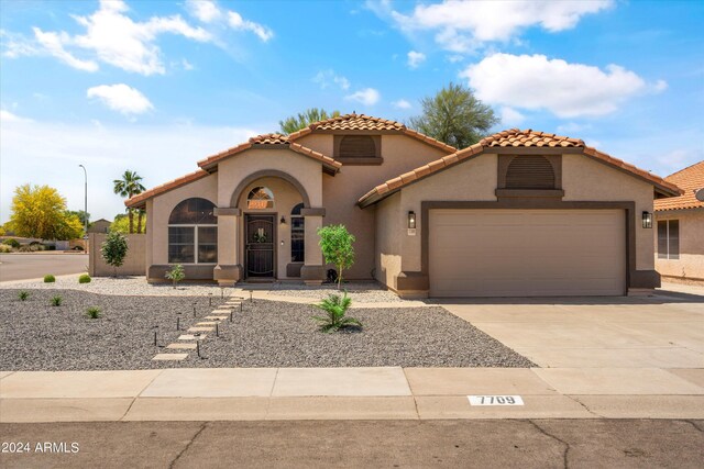 mediterranean / spanish-style home with a garage