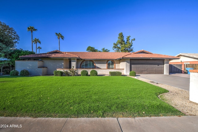 mediterranean / spanish house featuring a front yard and a garage