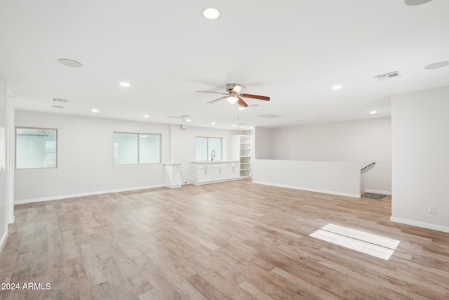 unfurnished living room with light wood-type flooring and ceiling fan