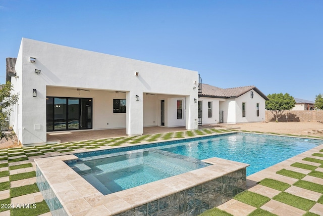 back of house featuring a pool with hot tub and a patio