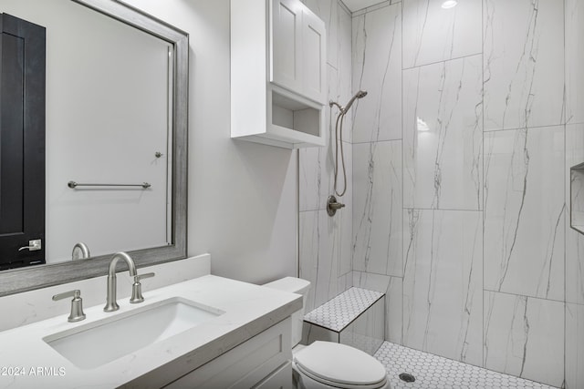 bathroom featuring vanity, toilet, and tiled shower