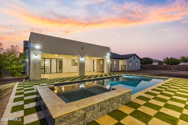 exterior space with a swimming pool with hot tub and a patio area