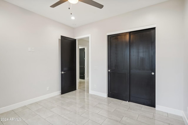 unfurnished bedroom with a closet, light tile patterned floors, and ceiling fan