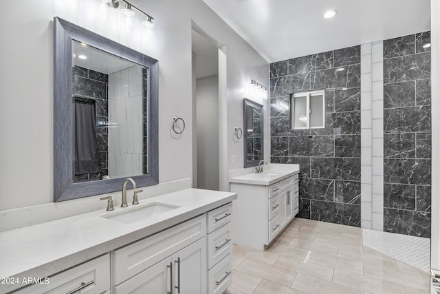 bathroom with vanity, tile walls, tile patterned flooring, and a tile shower