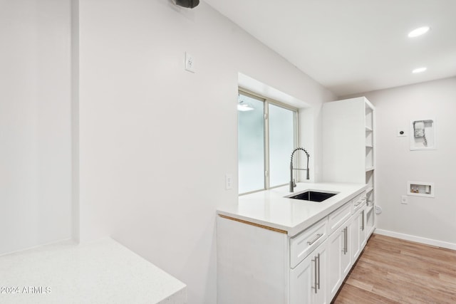 kitchen with white cabinetry, light hardwood / wood-style floors, and sink