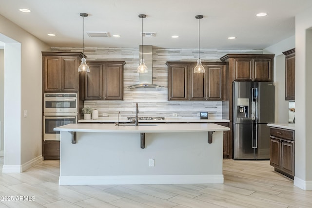 841 E Farmers Ln, Queen Creek, AZ 85140 - kitchen with stainless steel appliances, wall chimney range hood, light countertops, decorative backsplash, and a breakfast bar area