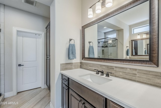 841 E Farmers Ln, Queen Creek, AZ 85140 - full bath featuring a stall shower, wood finished floors, vanity, backsplash, and baseboards