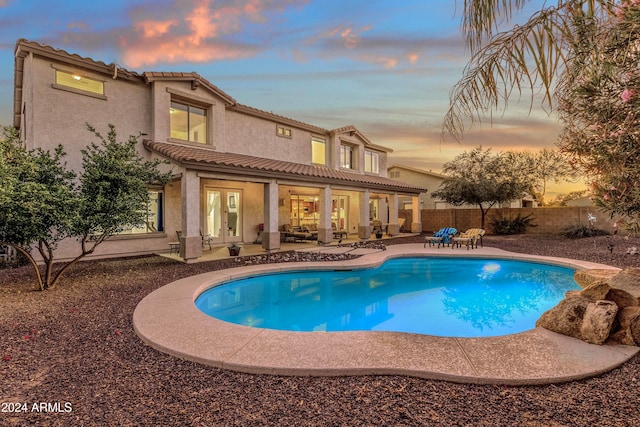 pool at dusk with a patio