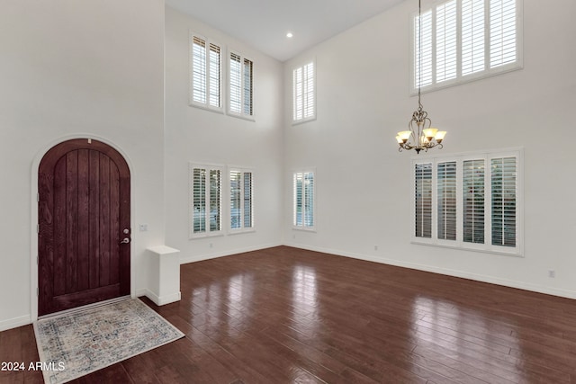 foyer with dark hardwood / wood-style flooring, a chandelier, and a high ceiling