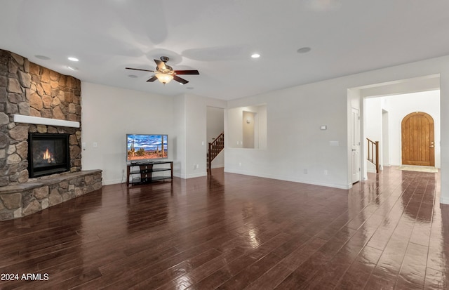 living room featuring ceiling fan, dark hardwood / wood-style flooring, and a fireplace