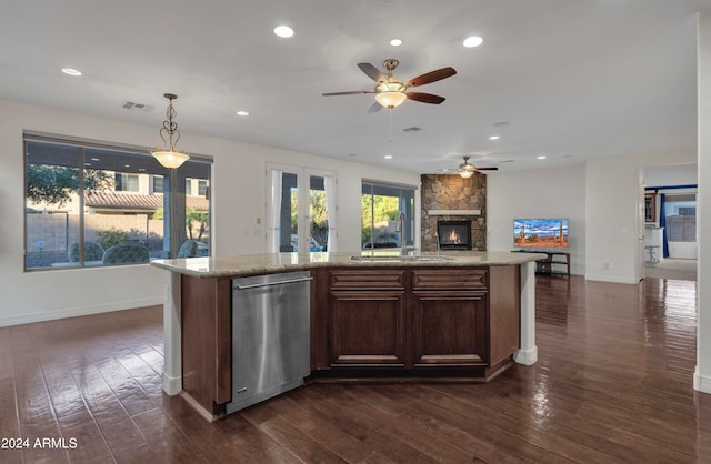 kitchen with stainless steel dishwasher, dark hardwood / wood-style floors, pendant lighting, and sink