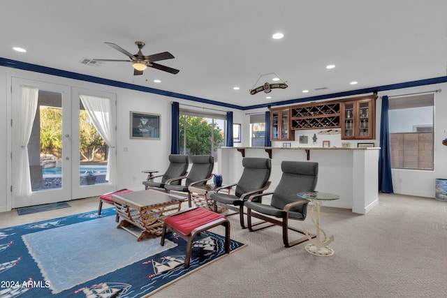 cinema room featuring plenty of natural light, ceiling fan, ornamental molding, and french doors